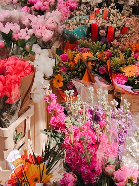 A vibrant display of freshly cut flowers arranged in various bouquets and bouquets wraps at Brixton Florist. The assortment includes pink roses, white peonies, orange and yellow daisies, and purple st